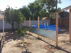 an above ground swimming pool in the middle of a yard with trees and fence around it