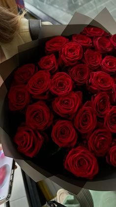 a woman holding a bouquet of red roses in front of her face and an instagram