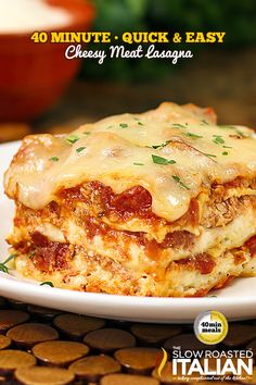 a white plate topped with lasagna covered in sauce and cheese on top of it