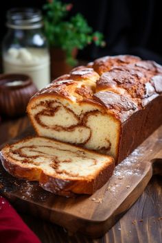 a loaf of cinnamon swirl bread sitting on top of a wooden cutting board