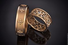 two gold wedding bands with diamonds on them, one is in the shape of a flower