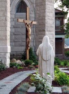 a statue of jesus on the cross in front of a church