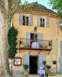 an old building with two balconies and blue shutters on the front door