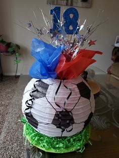 a birthday cake made to look like a soccer ball on top of grass and streamers