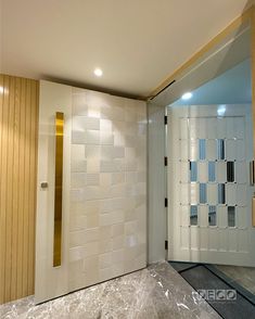 the interior of a modern bathroom with white and gold accents on the walls, along with a marble countertop