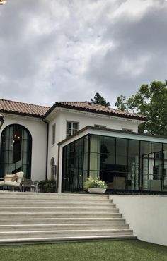 a large white house sitting on top of a lush green field