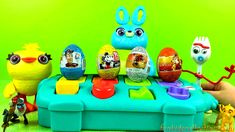 an assortment of toy eggs sitting on top of a blue box with characters around it