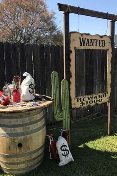 an old barrel is sitting in the grass next to a sign that says, wanted beware $ 500