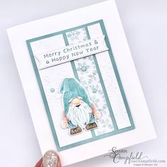 someone holding up a christmas card with a gnome on it