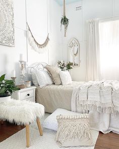 a bedroom with white walls and wooden flooring is decorated in bohou style