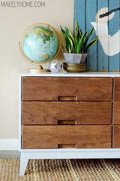 a wooden dresser with drawers and a globe on top