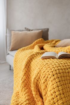 an open book sitting on top of a yellow blanket