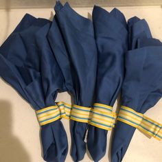 several blue cloths tied together with yellow and white striped ties on a counter top