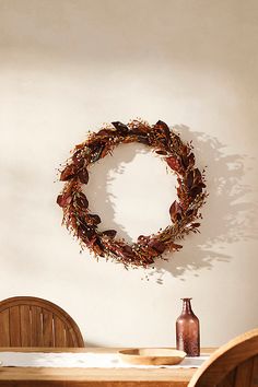 a wreath on the wall above a dining room table