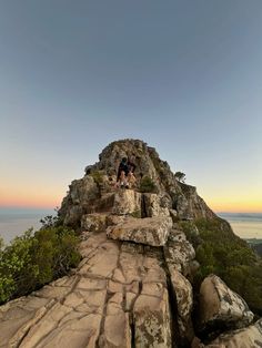 two people climbing up the side of a mountain