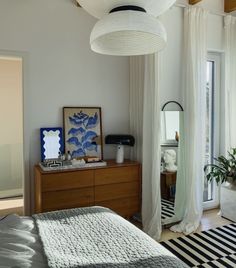 a bed room with a neatly made bed and a large mirror on the wall above it