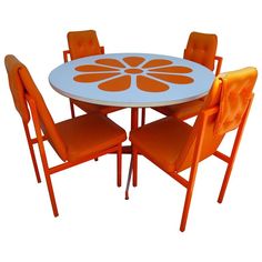 an orange and white table with four chairs around it, on a white background in the image