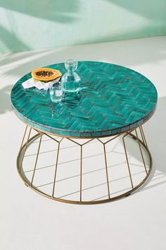 a table with a glass top and metal base on a white floor next to a pool