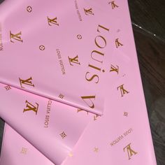 four pink sheets with gold lettering on them