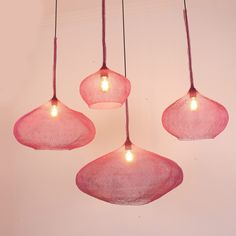 three pink lamps hanging from the ceiling