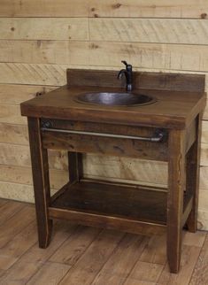 a rustic bathroom sink with wood paneling and wooden flooring in front of a wall