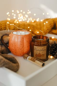 a candle and some candles are sitting on a white table with lights in the background