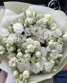 a bouquet of white flowers in someone's lap