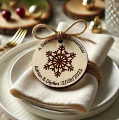 a white plate topped with a wooden snowflake ornament on top of a napkin