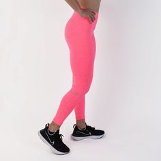 a woman in pink leggings with her hands on her hips