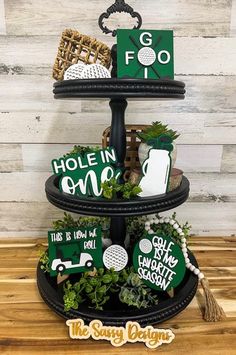 a three tiered tray with green and white items on it, along with the words hole in one