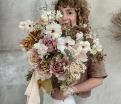 a woman holding a large bouquet of flowers