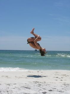 a person jumping in the air on a beach