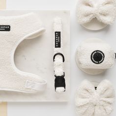 three pairs of white slippers, one with a bow tie and the other with a hat