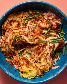 a blue bowl filled with food on top of a table