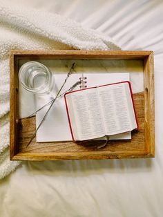 an open book with a pair of scissors on top of it sitting in a wooden frame