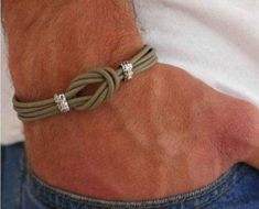 a man wearing a bracelet with two diamonds on it