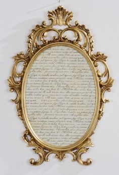 a gold framed mirror with writing on it