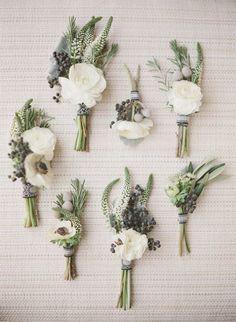 the bridal bouquets are laid out in rows on the table top, with greenery and flowers