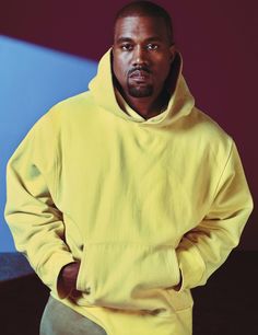 a man in a yellow hoodie standing with his hands on his hips