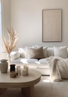 a living room filled with white furniture and pillows