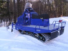 a snowmobile is parked in the snow near some trees