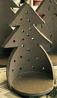 two metal christmas trees sitting on top of a table next to each other with holes in them