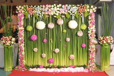 an arrangement of flowers and grass on display