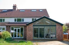 a large brick house sitting next to a lush green yard