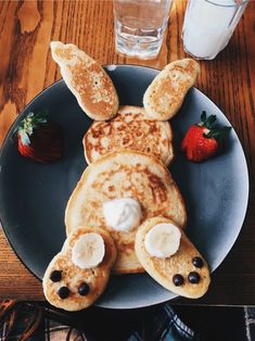 a plate topped with pancakes covered in toppings next to a strawberries and milk