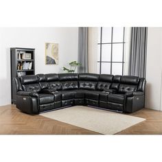 a black leather sectional sofa sitting on top of a wooden floor