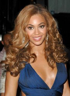 a beautiful woman in a blue dress posing for the camera with her hair blowing back