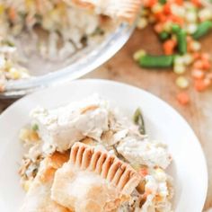 a white plate topped with a slice of pie covered in mashed potatoes and veggies