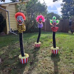 three clowns made out of popcorn buckets in the yard