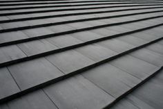 the roof of a building with many rows of black tiles